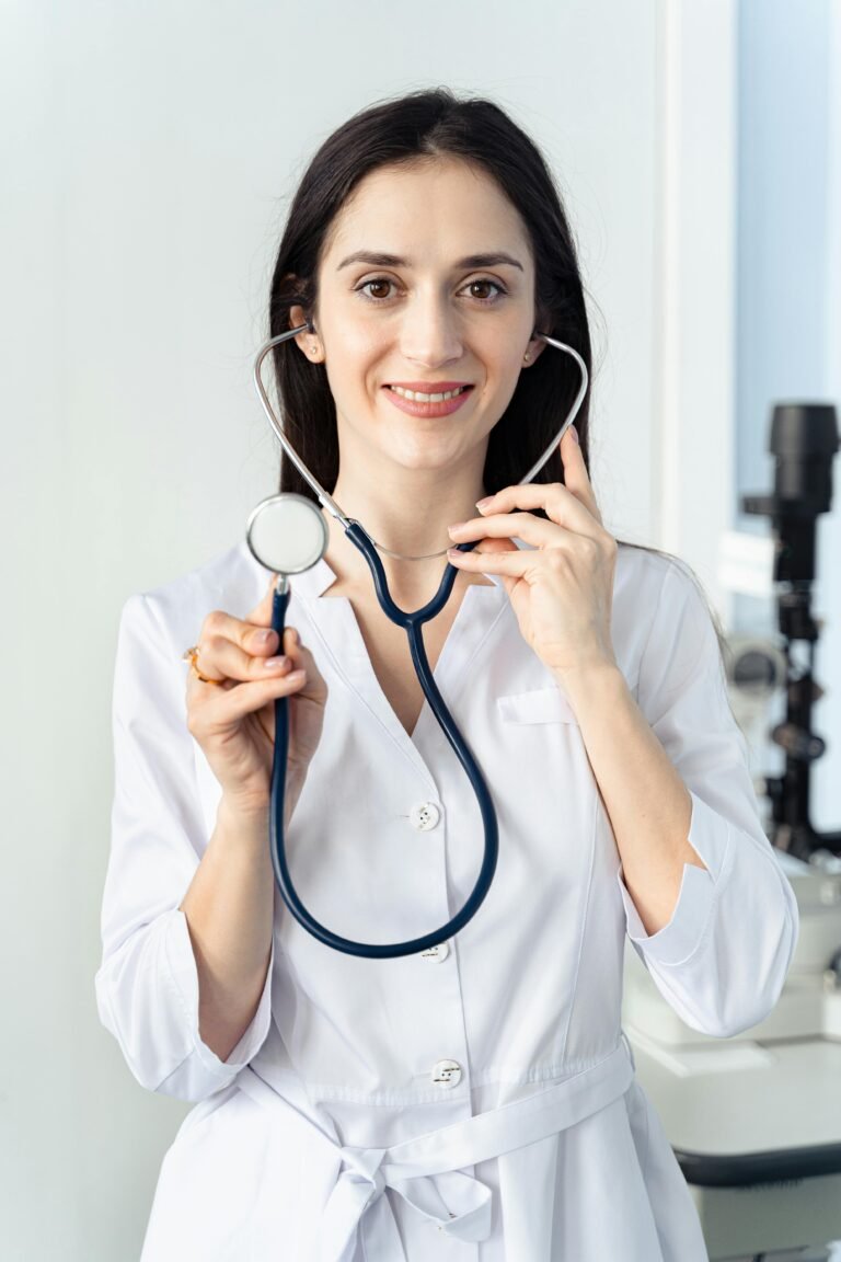 Portrait of a smiling female doctor holding a stethoscope, showcasing professionalism in a healthcare setting.